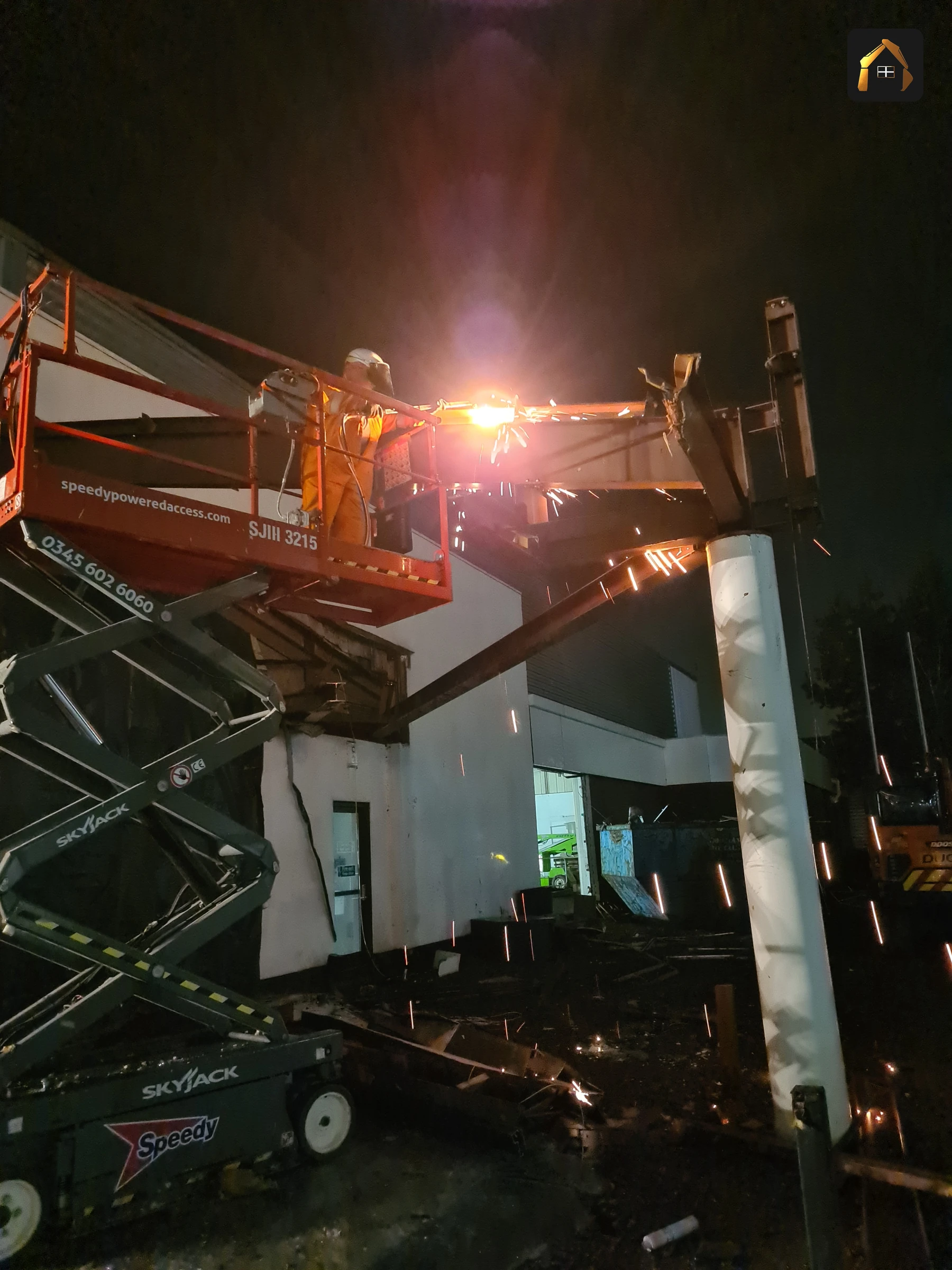 Sparks falling from the steel frame during night hot cutting at the BMW dealership in Exeter