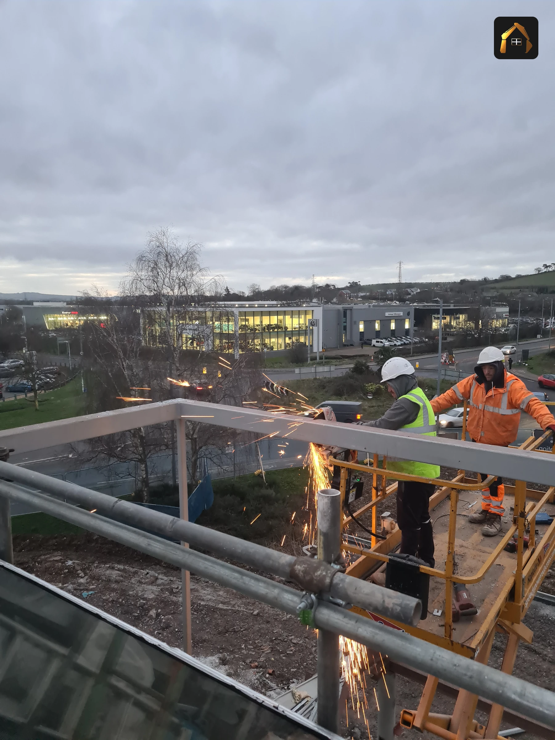 Workers hot cutting steel beams at height at the BMW dealership in Exeter