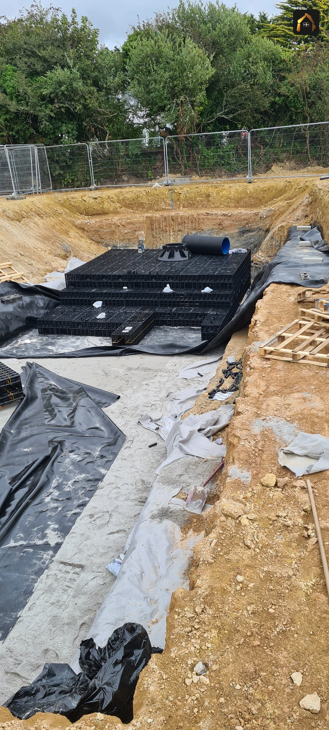 Attenuation crates and geotextile being laid in a large excavation at Goonhavern