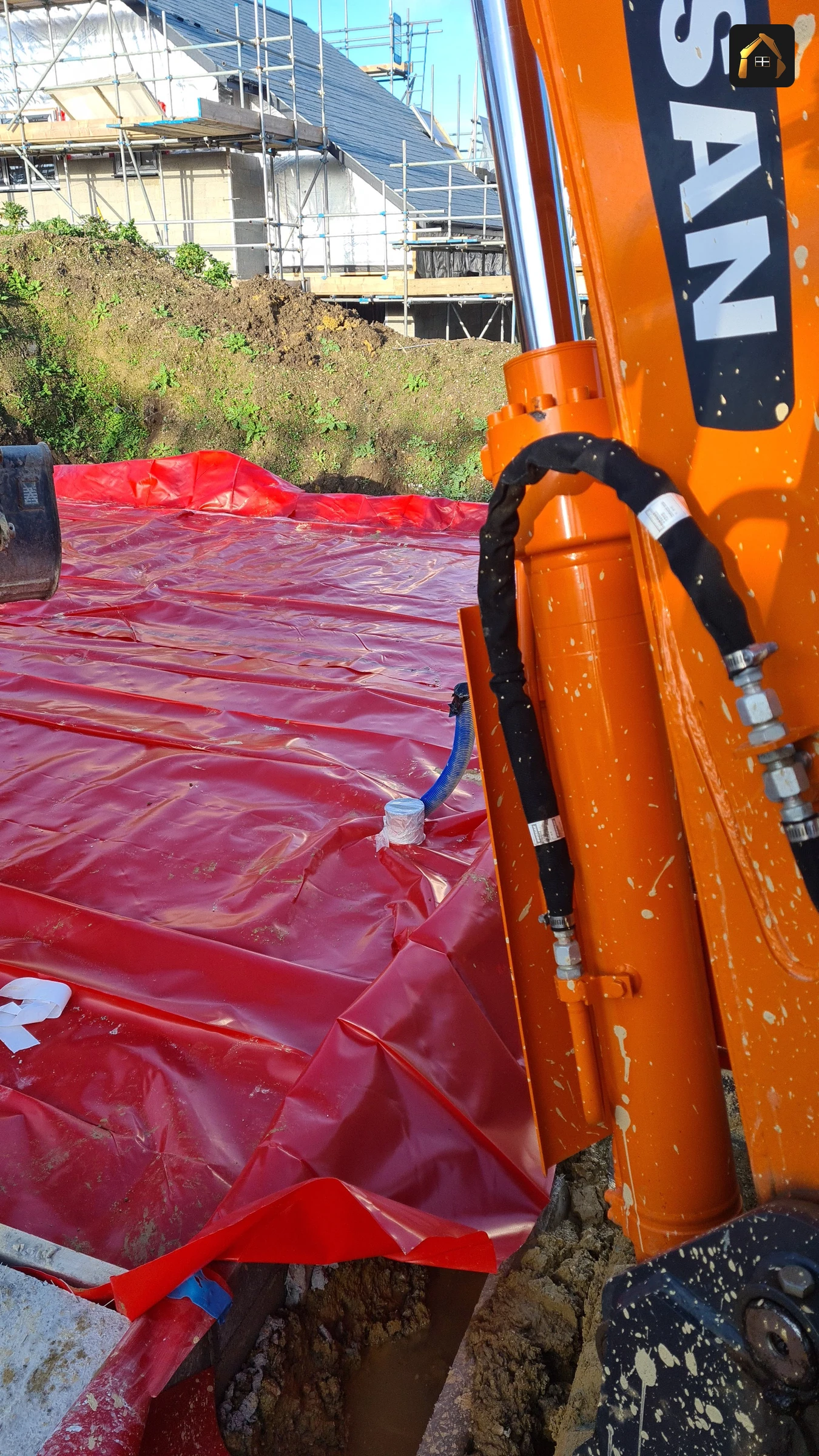 Red radon membrane laid over a slab with pipework in Goonhavern