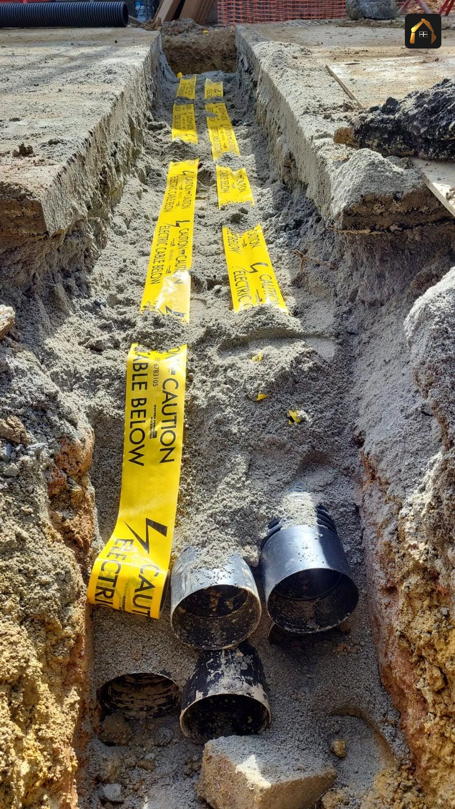 Yellow service ducts and twinwall pipe laid together in an open trench at Goonhavern