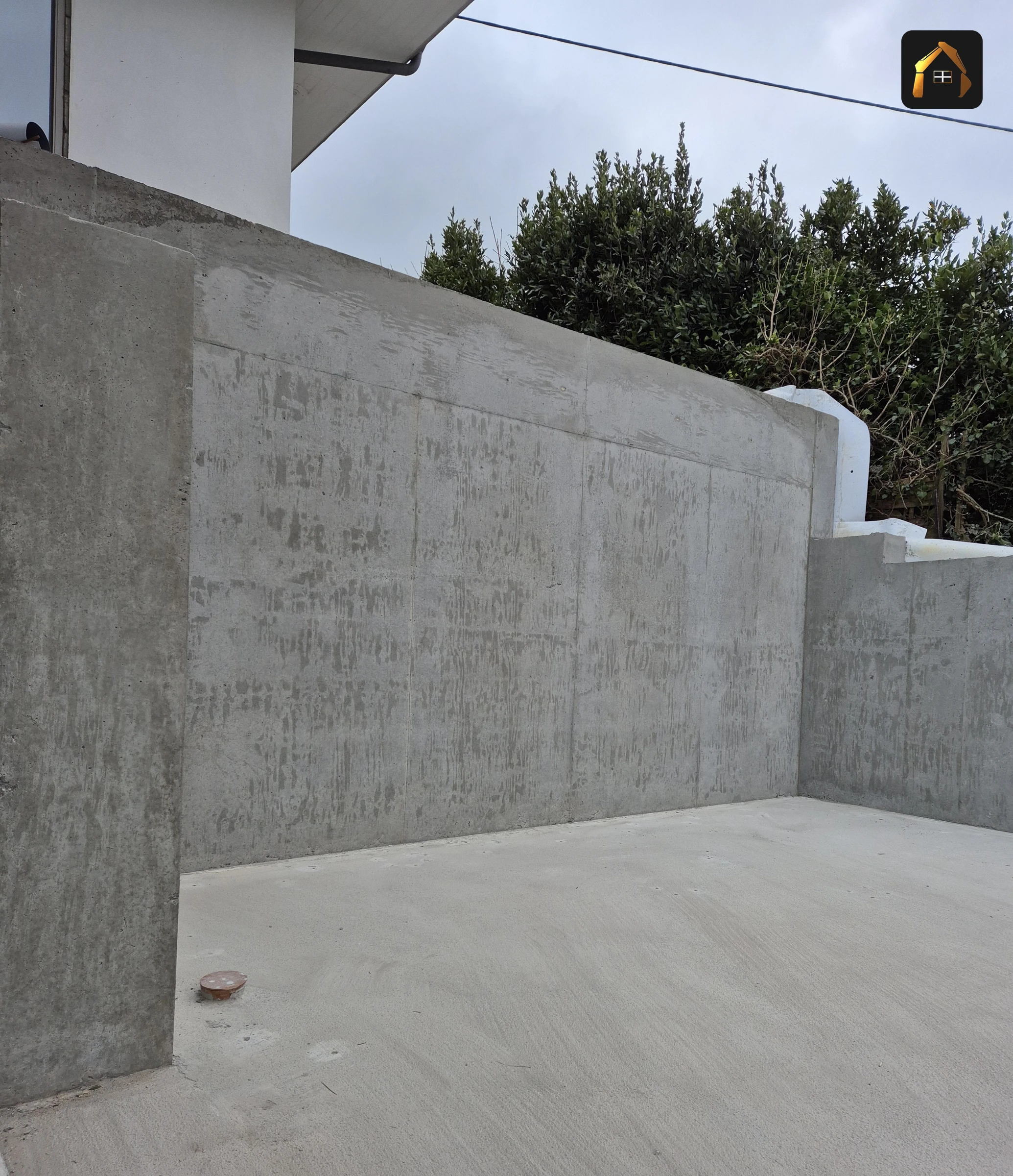 Completed reinforced concrete retaining wall with a board marked face in Helford