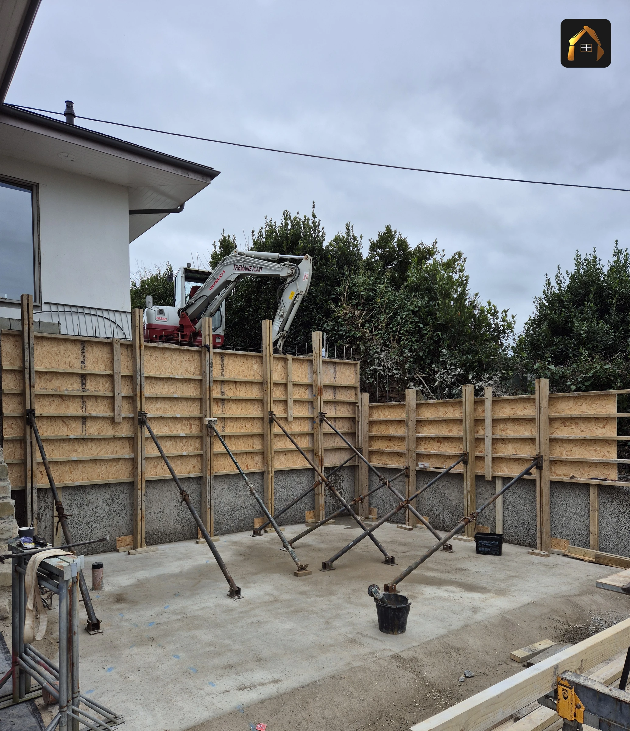Plywood formwork erected along the line of a new retaining wall in Helford