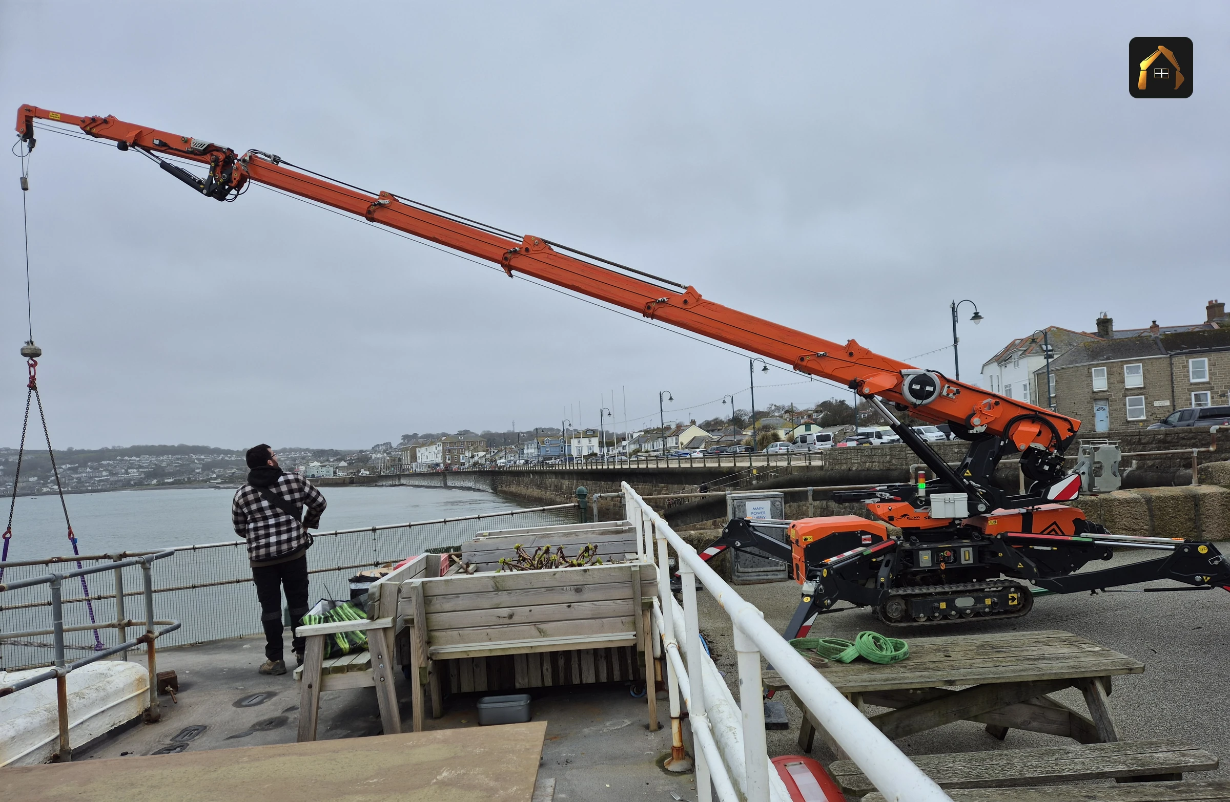 Crane working along the Jubilee Pool sea wall over the tide in Penzance