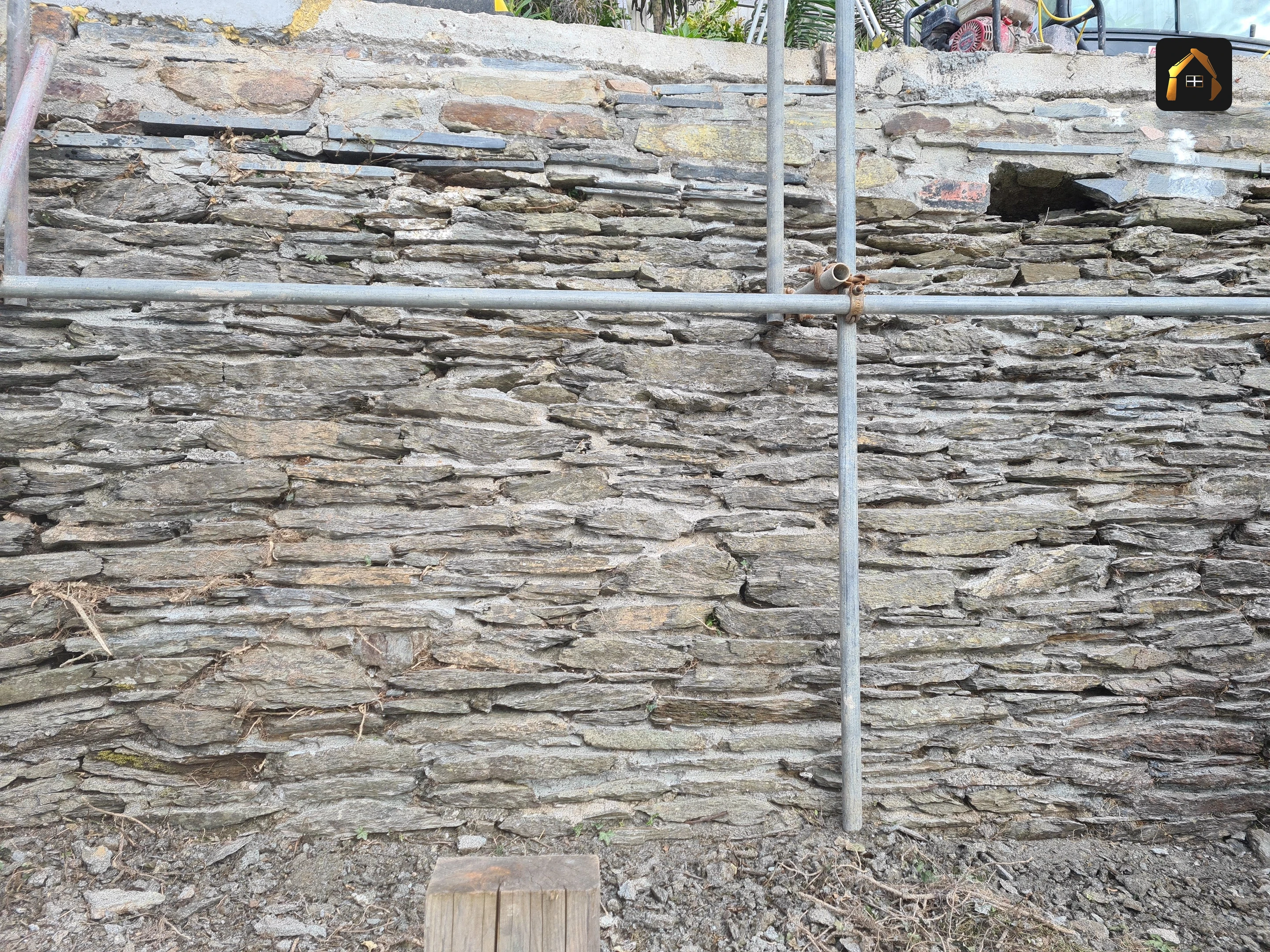 Completed coursed random rubble stone retaining wall in Looe