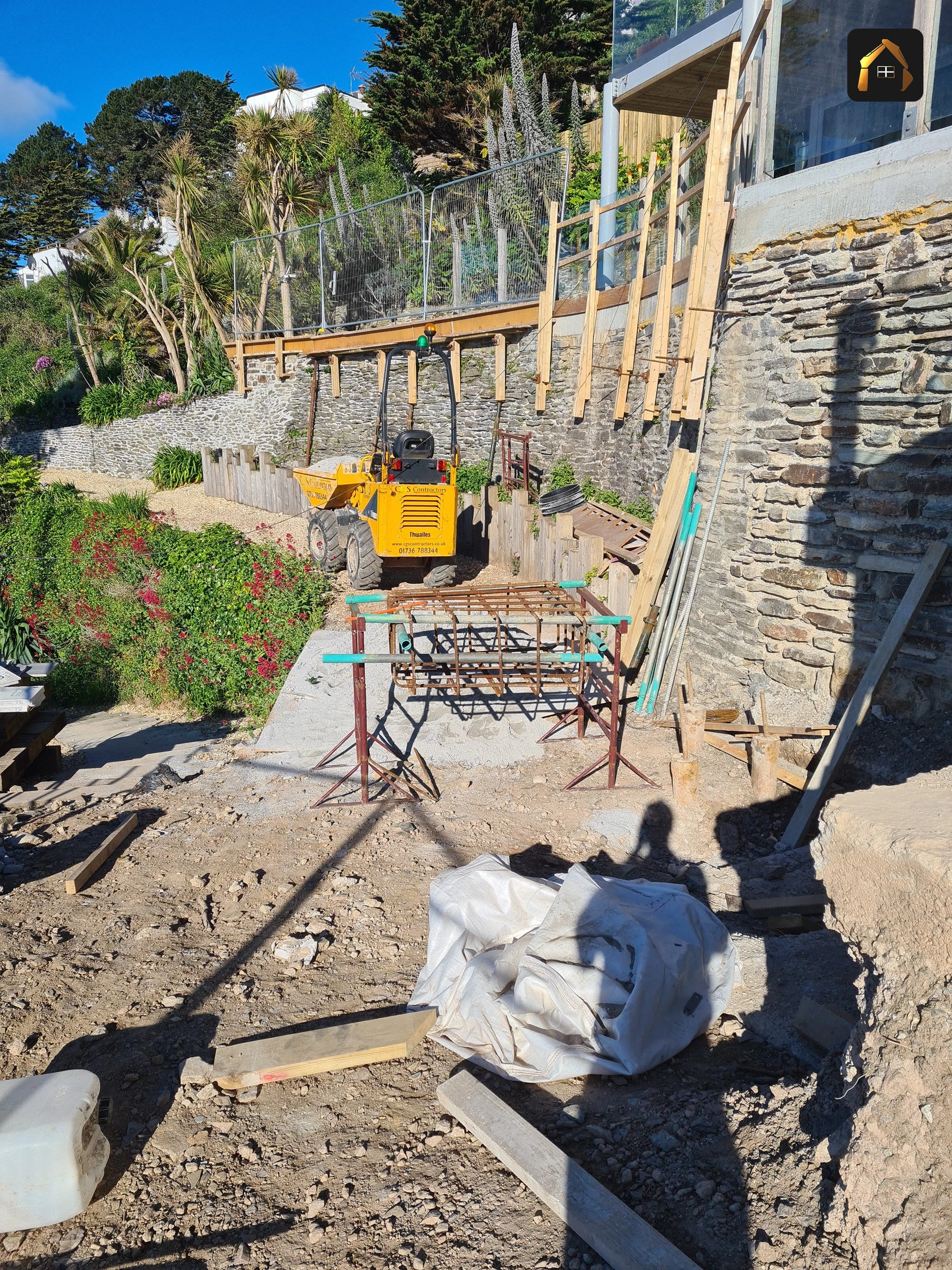 Workers hauling material up a steep slope on ropes in Looe