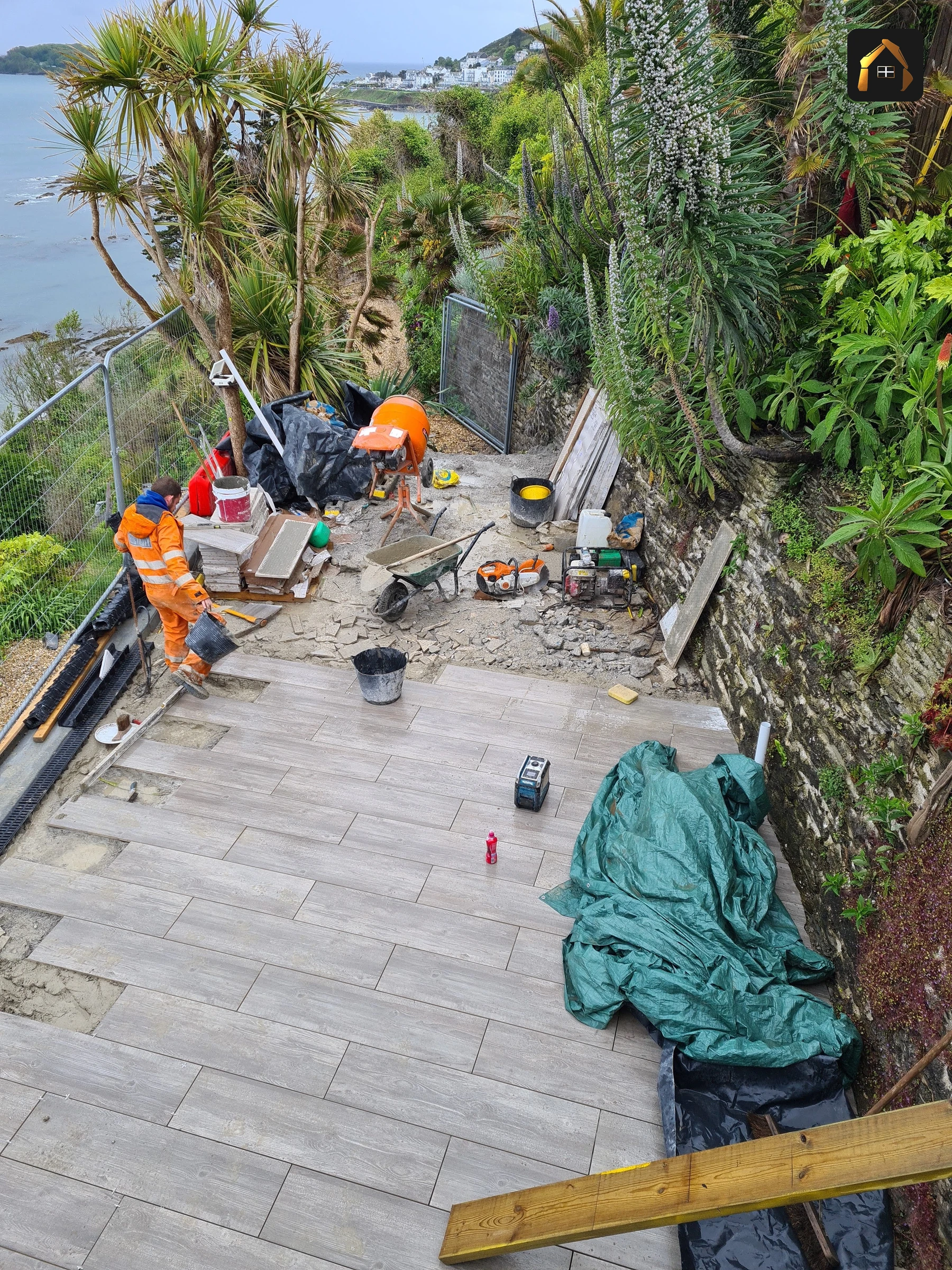 Workers laying large stone paving slabs in Looe