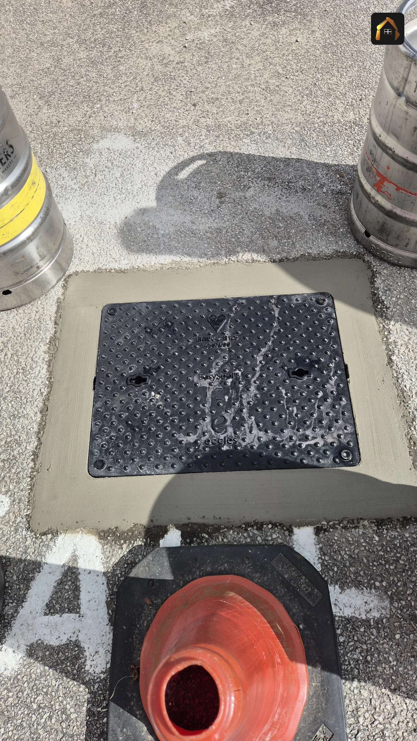 Completed manhole with a new cover bedded flush in concrete in Ludgvan