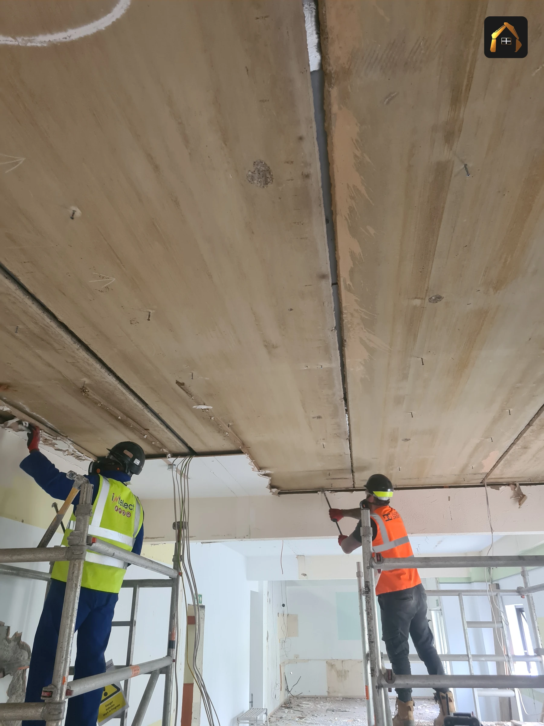 Two workers on tower scaffolds removing ceiling services during the Fal Fish strip out in Redruth
