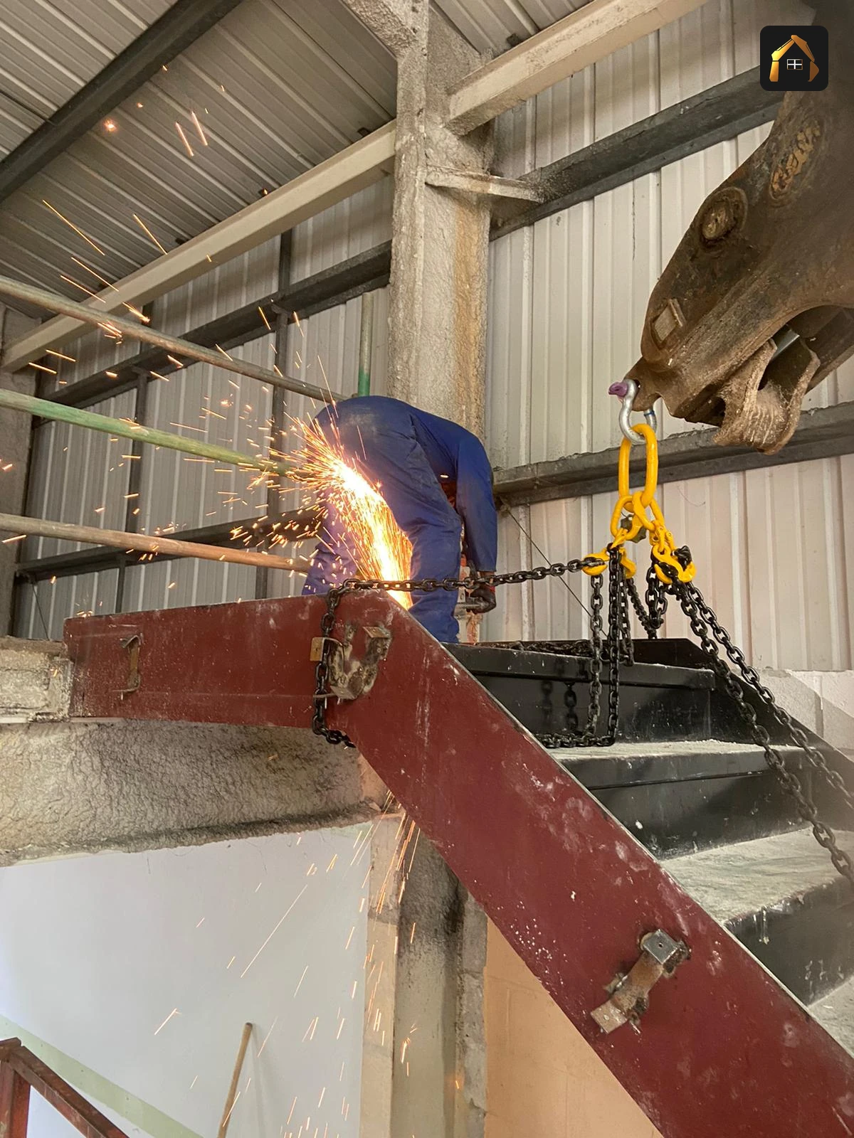 Worker hot cutting a steel beam with sparks falling during the Fal Fish demolition in Redruth