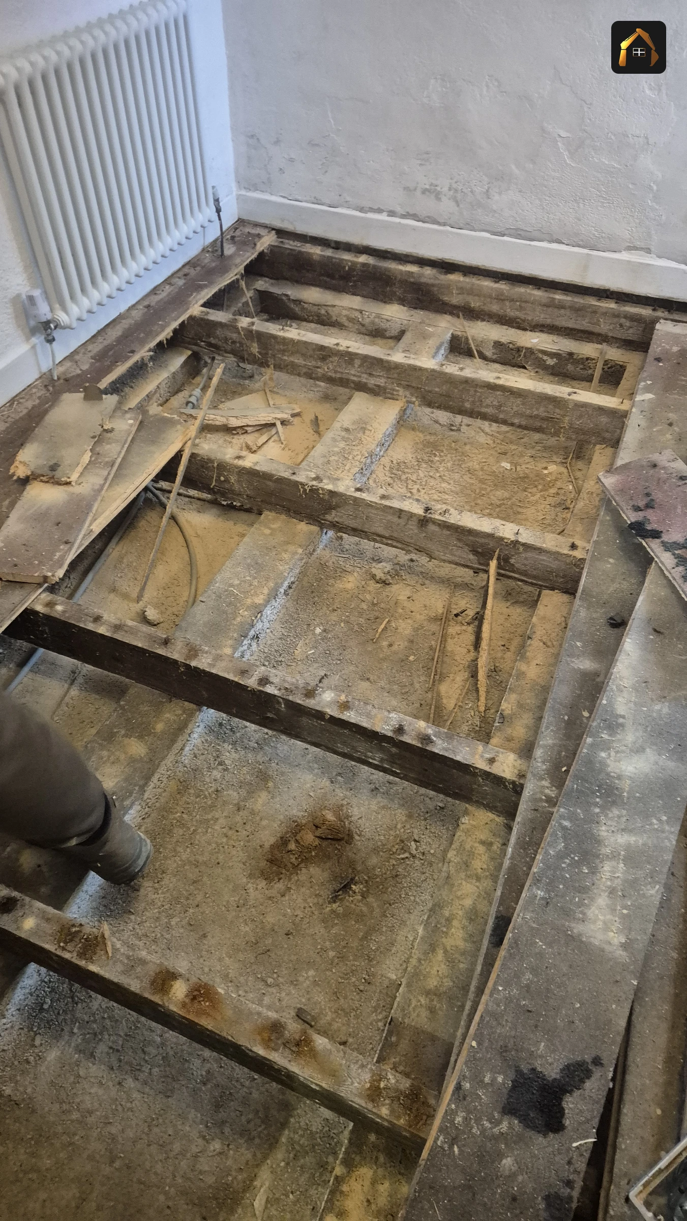 Before work: rotten timber floorboards lifted to expose the joists in Sennen Cove